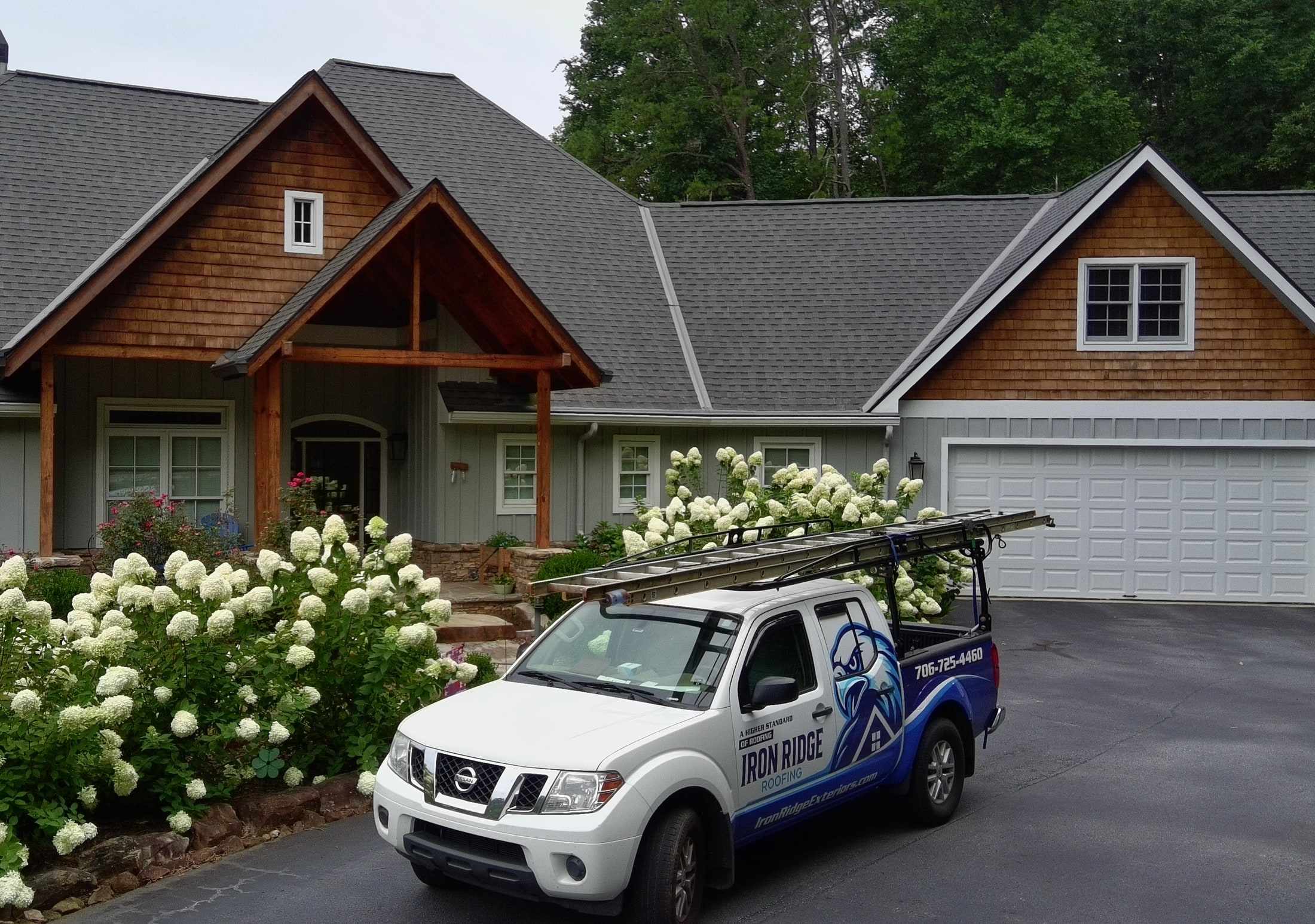 Iron Ridge Roofing truck in front of a home with a new shingle roof
