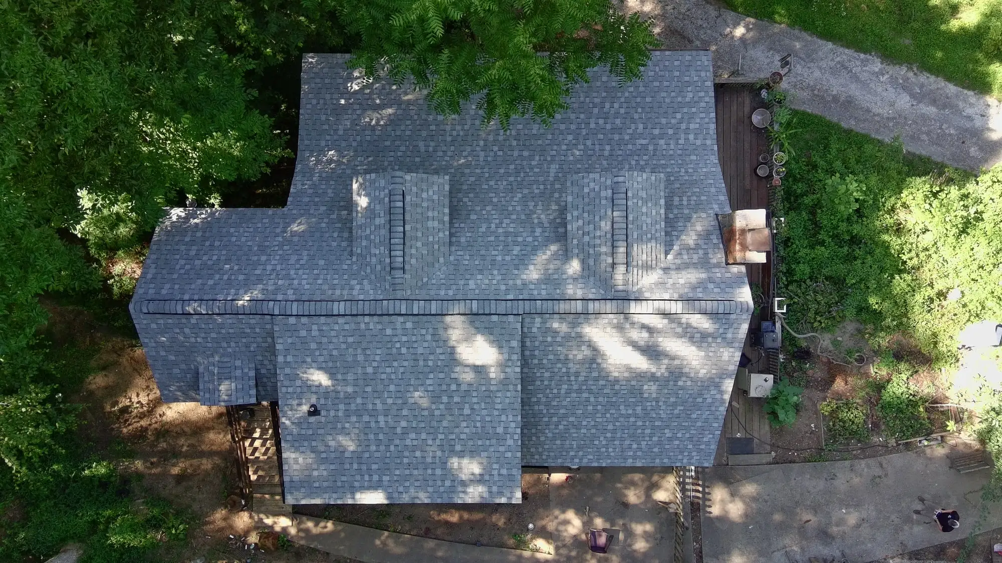 Top-down drone view of a home with a new gray shingle roof