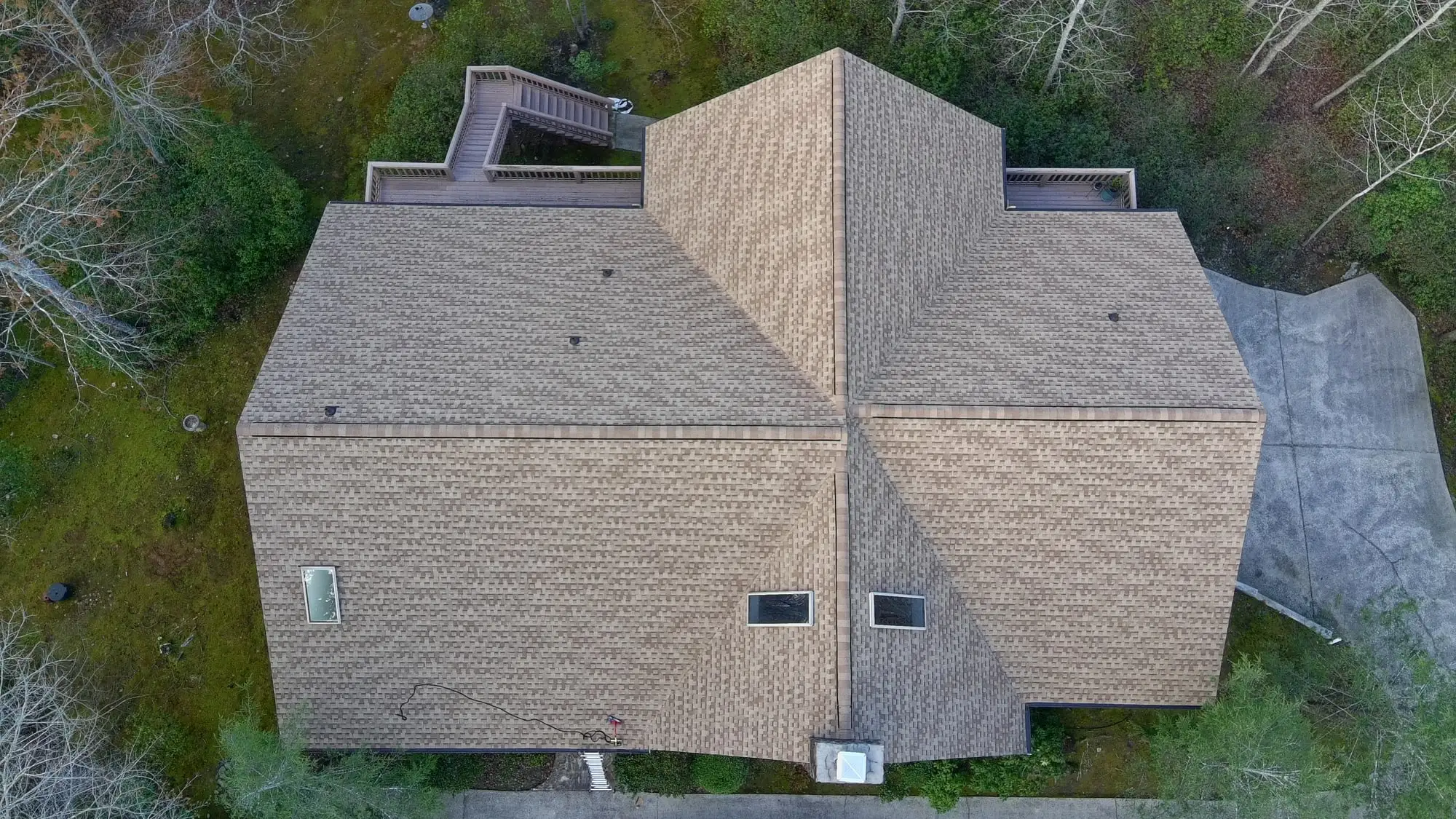 Top-down drone view of a home with a new tan architectural shingle roof