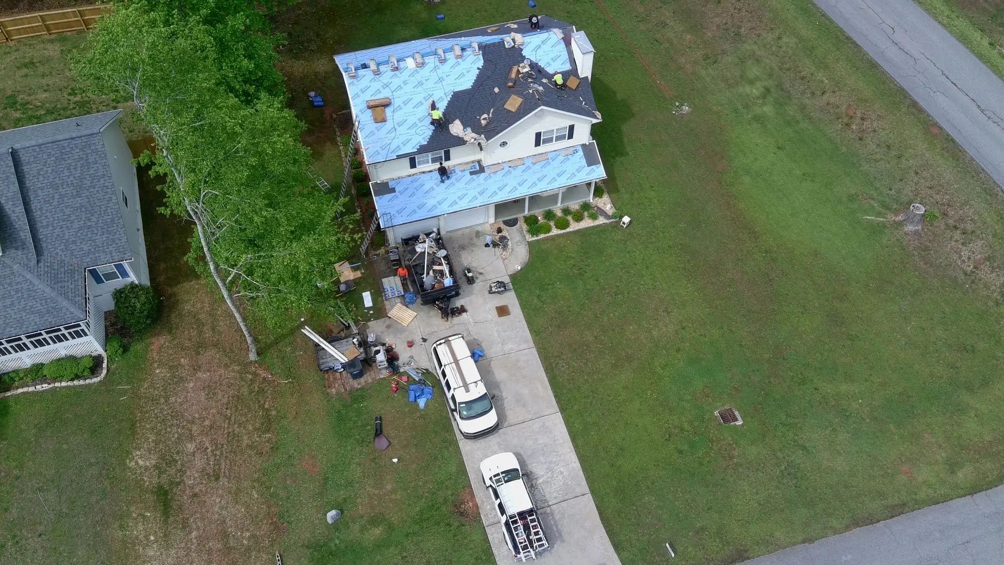Aerial view of an Iron Ridge roof replacement in progress, with the truck and trailer in the driveway