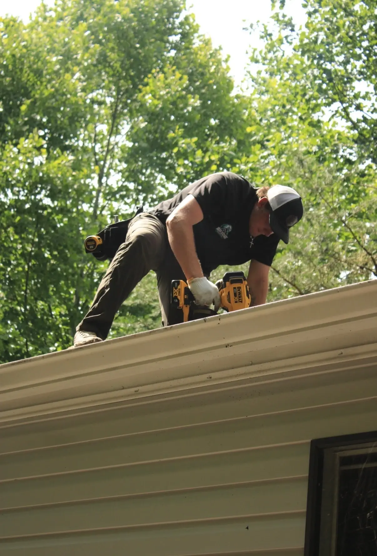 Logan, owner of Iron Ridge Roofing, installing a gutter on a home