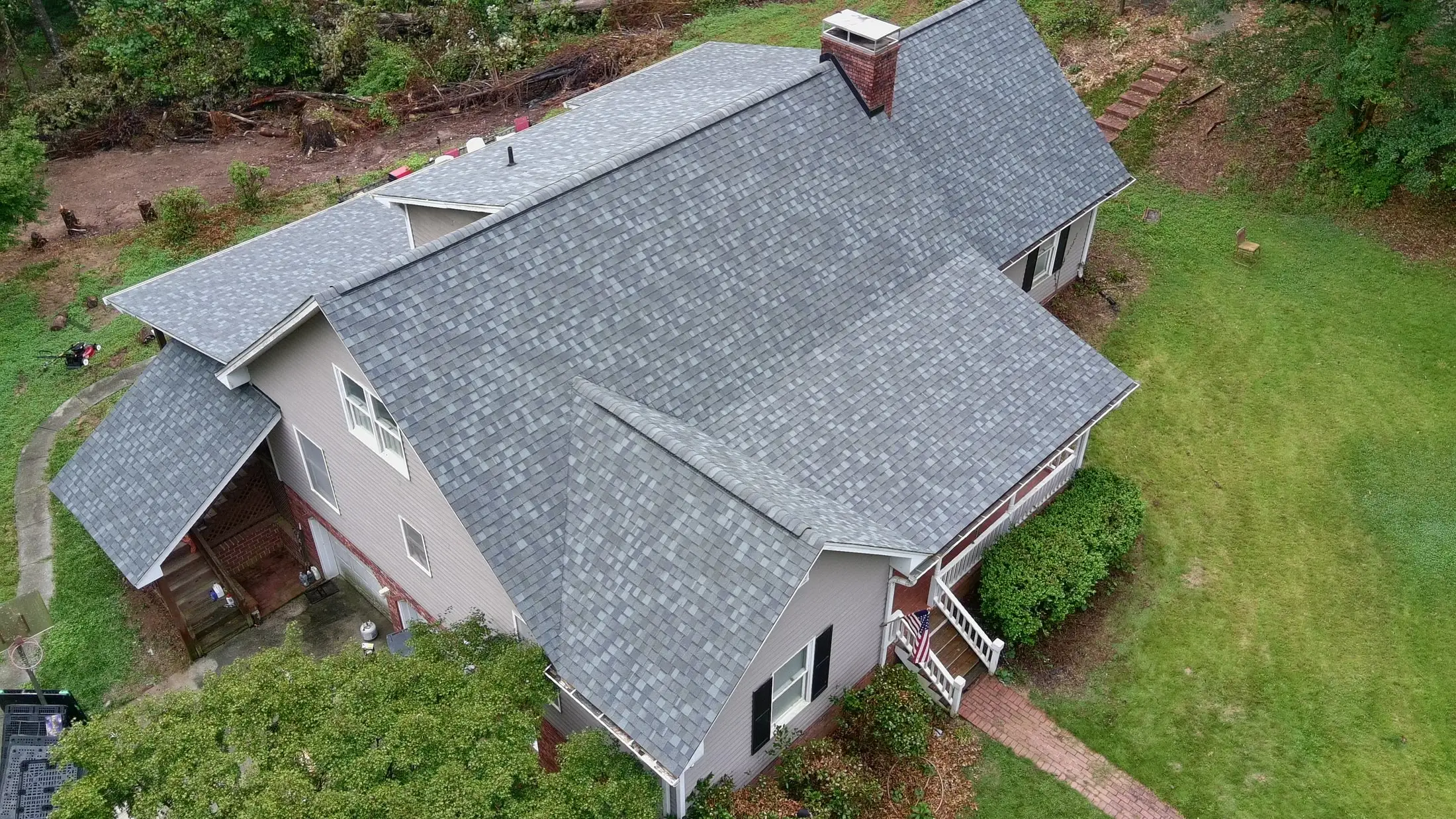 Two-story home with a new gray architectural shingle roof installed by Iron Ridge Roofing