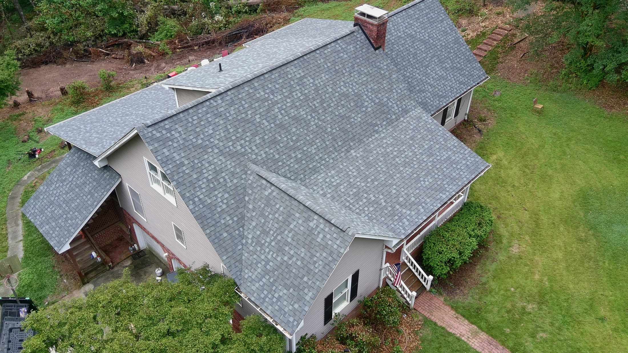 Two-story home with a newly installed gray architectural shingle roof by Iron Ridge Roofing