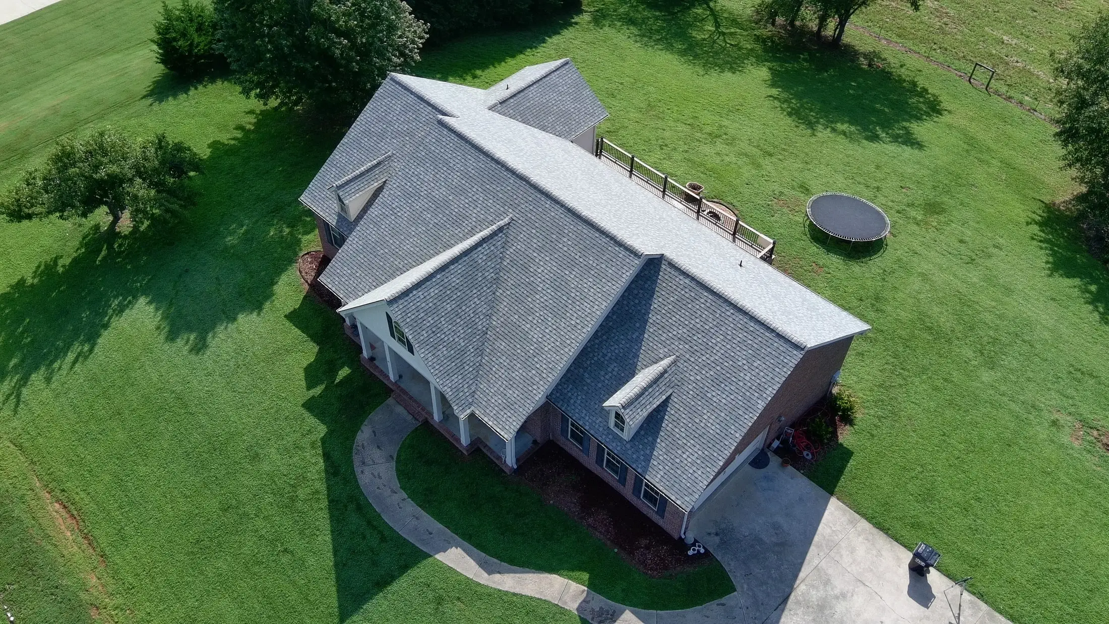 Aerial view of a brick home with a new gray architectural shingle roof