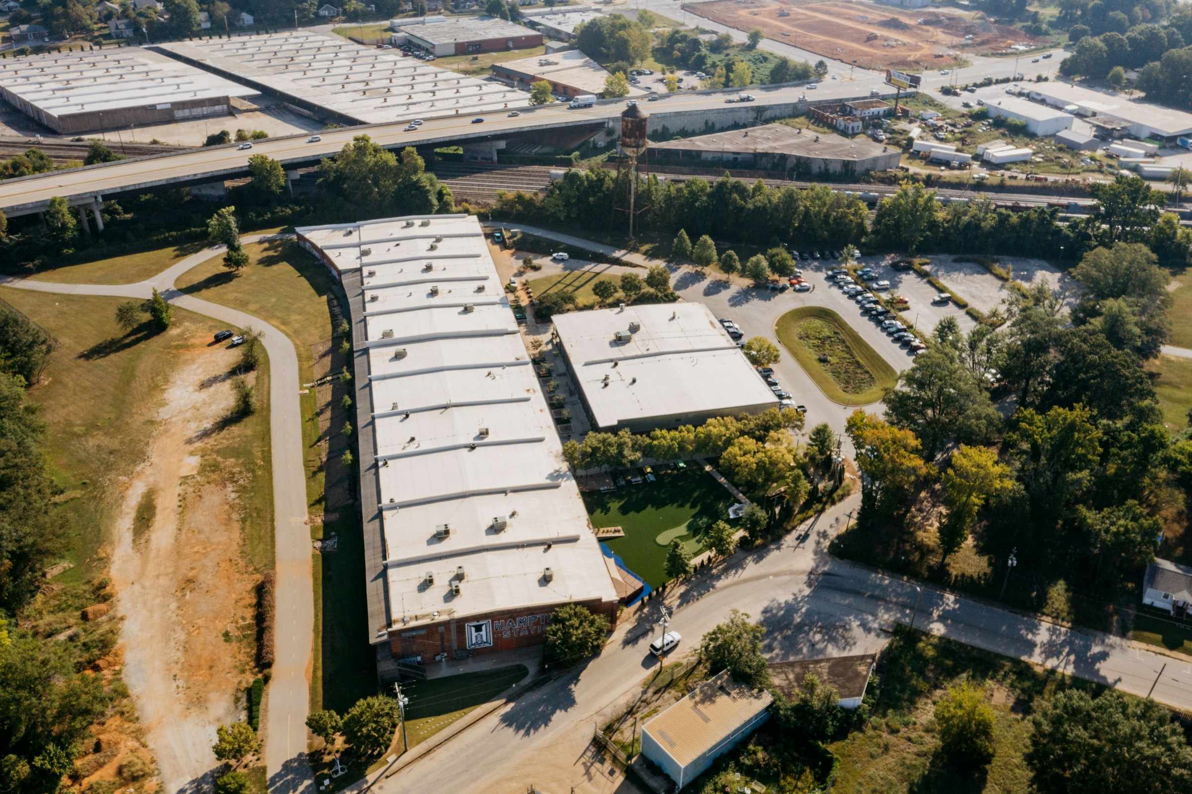 Aerial view of commercial buildings with white flat roofs surrounded by trees